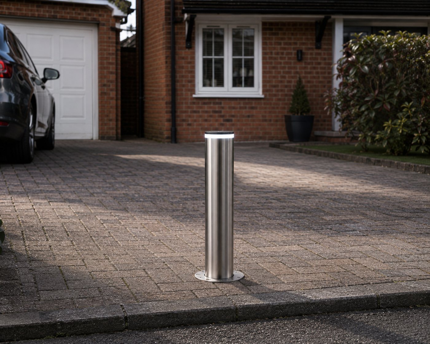 A RiseGuard bollard raised on a block-paved driveway